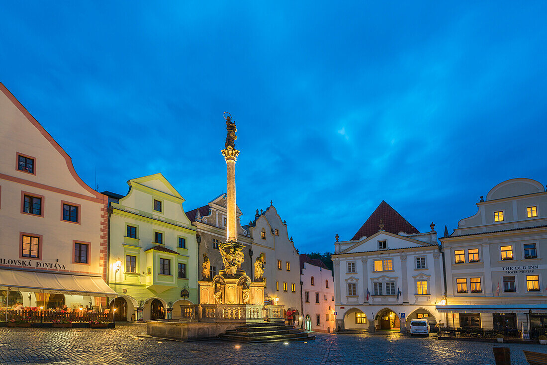 Brunnen und Pestsäule mit traditionellen Häusern mit Giebeln im Hintergrund in der Dämmerung, Namesti Svornosti Platz im historischen Zentrum, UNESCO-Weltkulturerbe, Cesky Krumlov, Tschechische Republik (Tschechien), Europa