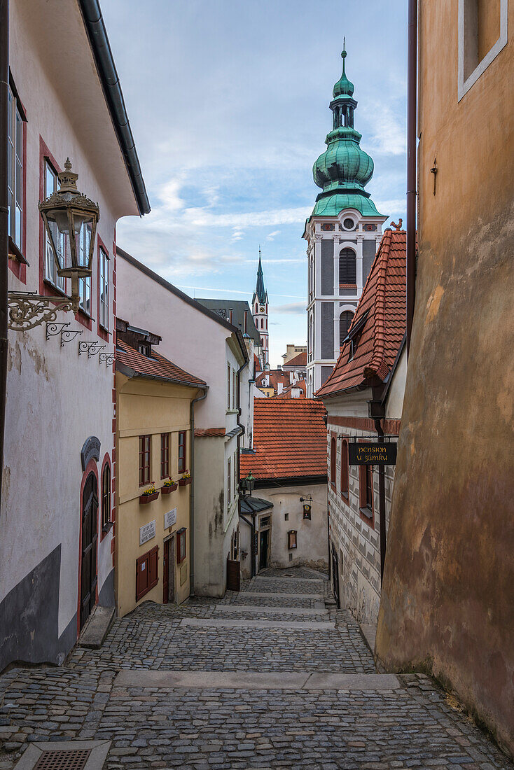 Narrow alley with view of towers of St. Jost Church and Church of St. Vitus in background, UNESCO World Heritage Site, Cesky Krumlov, Czech Republic (Czechia), Europe