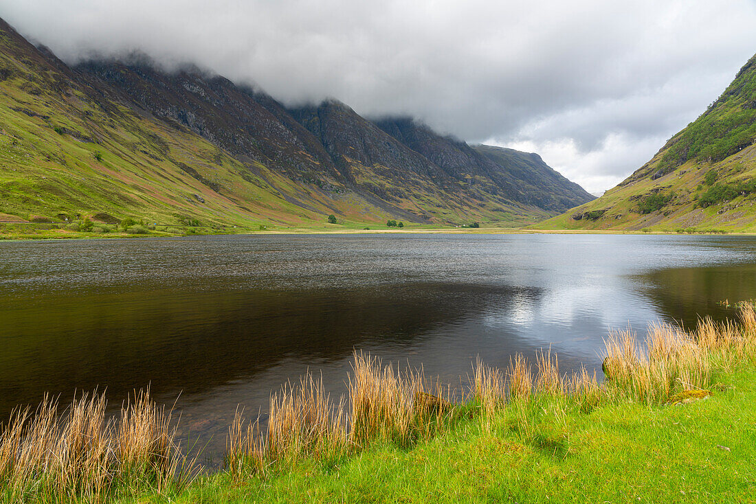 Loch Achtriochtan in valley against cloudy sky, Glencoe, Scottish Highlands, Scotland, United Kingdom, Europe
