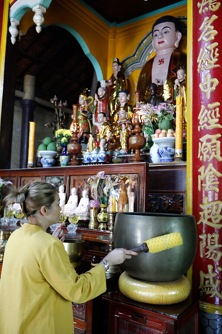 Rong Thanh Temple, Vietnamese Buddhist woman using a giant singing bowl, Tan Chau, Vietnam, Indochina, Southeast Asia, Asia