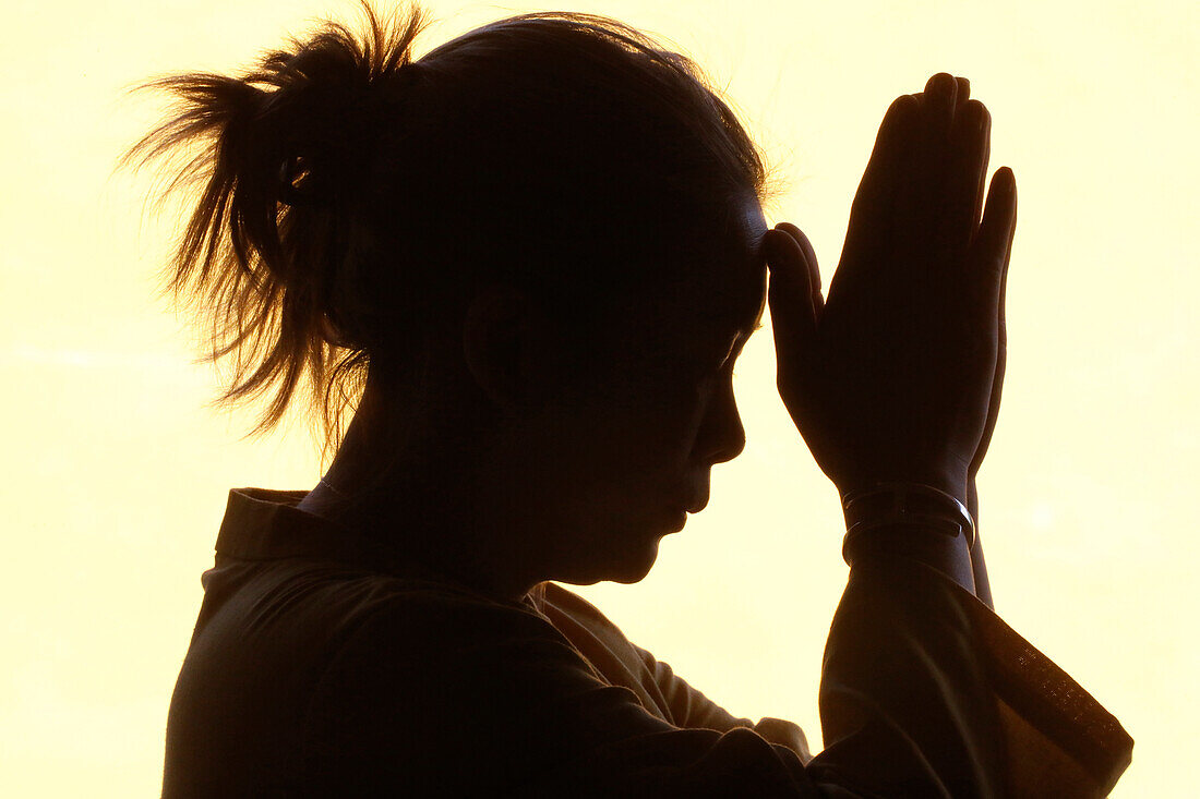 Silhouette of woman praying in temple, Faith and spirituality concept, Vietnam, Indochina, Southeast Asia, Asia