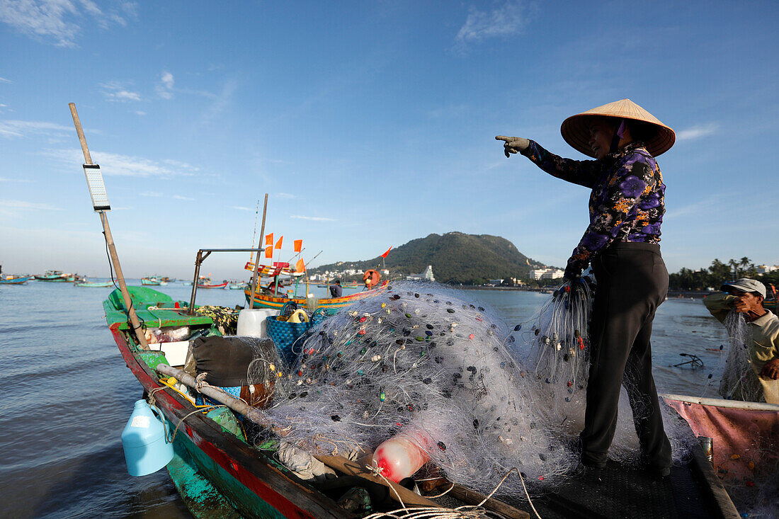 Frau mit traditionellem vietnamesischem Kegelhut beim Reparieren von Fischernetzen, Hang Dua Bucht, Vung Tau, Vietnam, Indochina, Südostasien, Asien