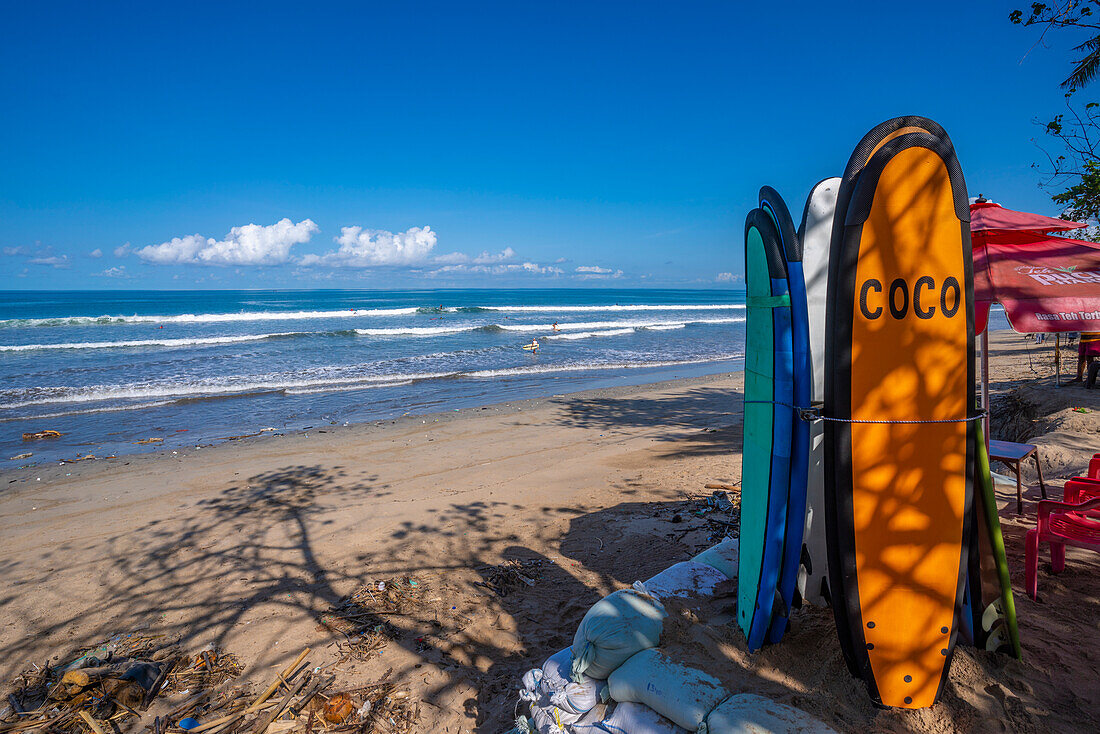 View of surf boards and vendors on sunny morning on Kuta Beach, Kuta, Bali, Indonesia, South East Asia, Asia