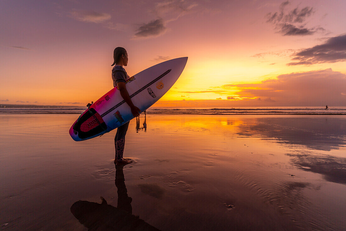 Blick auf einen Surfer am Kuta Beach bei Sonnenuntergang, Kuta, Bali, Indonesien, Südostasien, Asien