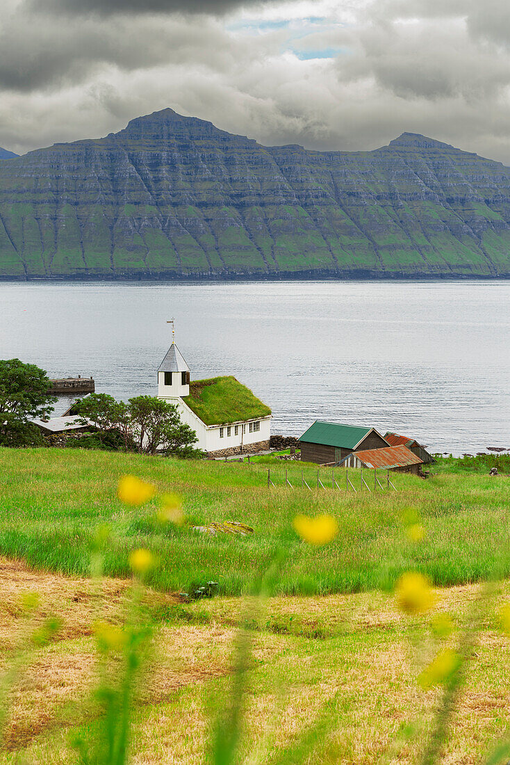 Die kleine weiße Kirche von Oyndarfjordur mit Gras auf dem Dach (Torfdach) mit Blick auf das Meer, Gemeinde Runavikar, Insel Eysturoy, Färöer Inseln, Dänemark, Nordeuropa, Europa
