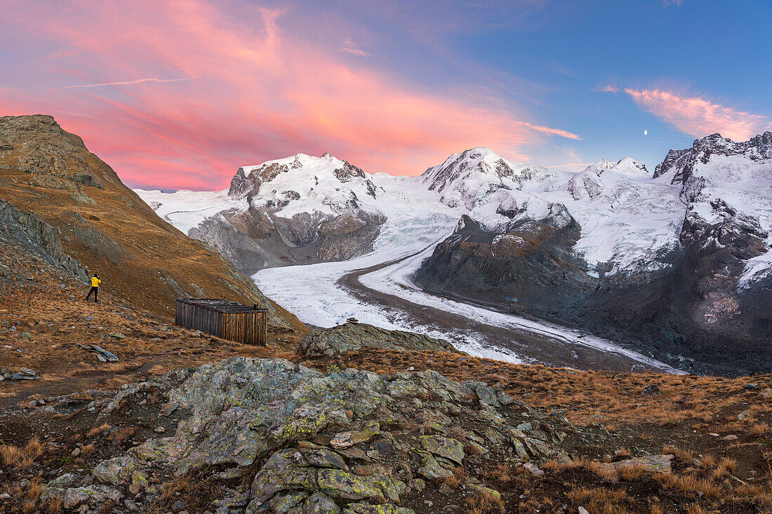 Hiker admiring snow covered peaks of Monte Rosa massif and the Gorner Glacier (Gornergletscher), Gornergrat, Zermatt, Valais Canton, Swiss Alps, Switzerland, Europe