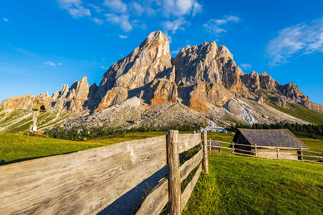 Berghütte in grünen Wiesen unter dem Massiv des Sass de Putia bei Sonnenuntergang, Passo delle Erbe, Dolomiten, Puez-Geisler, Bezirk Bozen, Südtirol, Italien, Europa