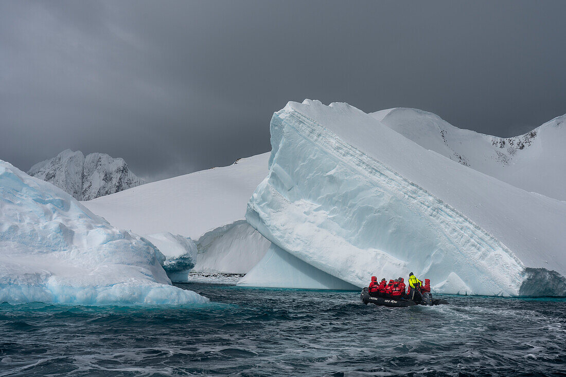 Touristen in einem Schlauchboot bei der Erkundung der Pleneau-Insel, Antarktis, Polargebiete