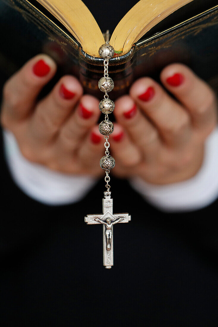 Woman reading the Bible, close up on vintage rosary with crucifix, Faith and religion, France, Europe