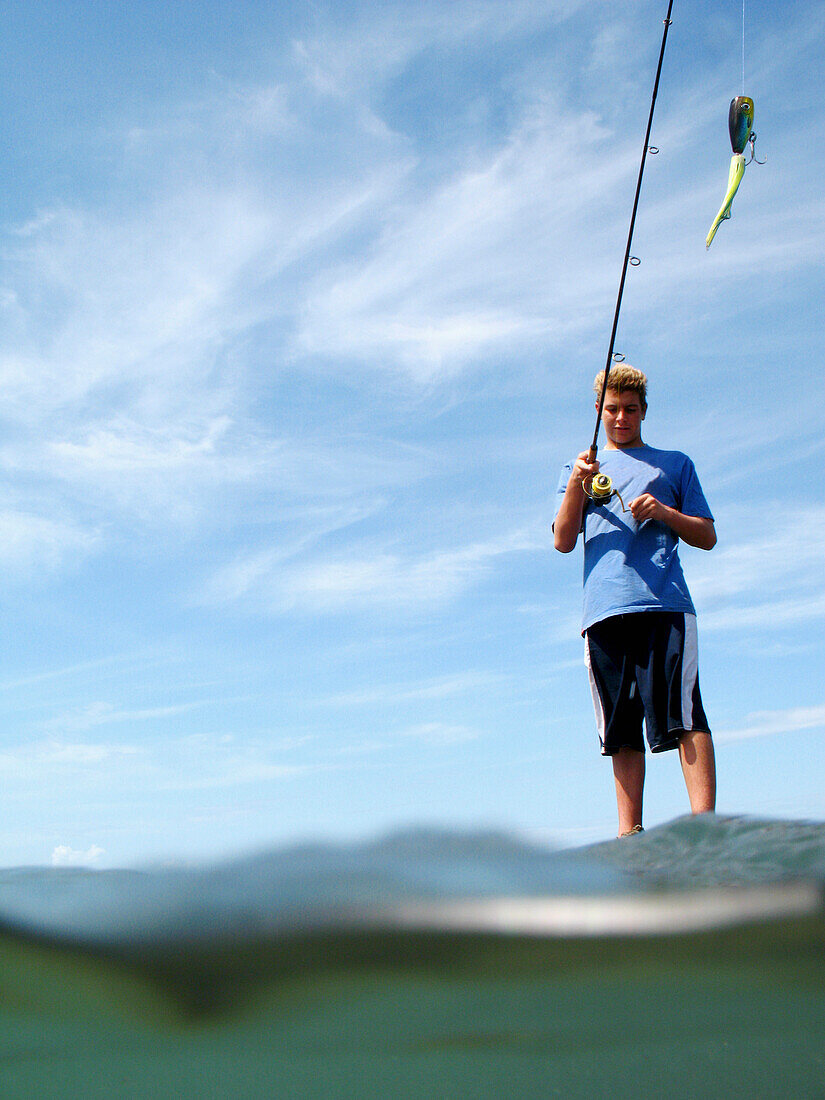 Young Man Fishing In Sea, Split Level