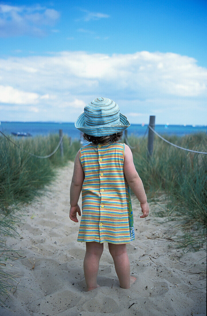 Young Girl On The Path Through Sand Dunes On Beach