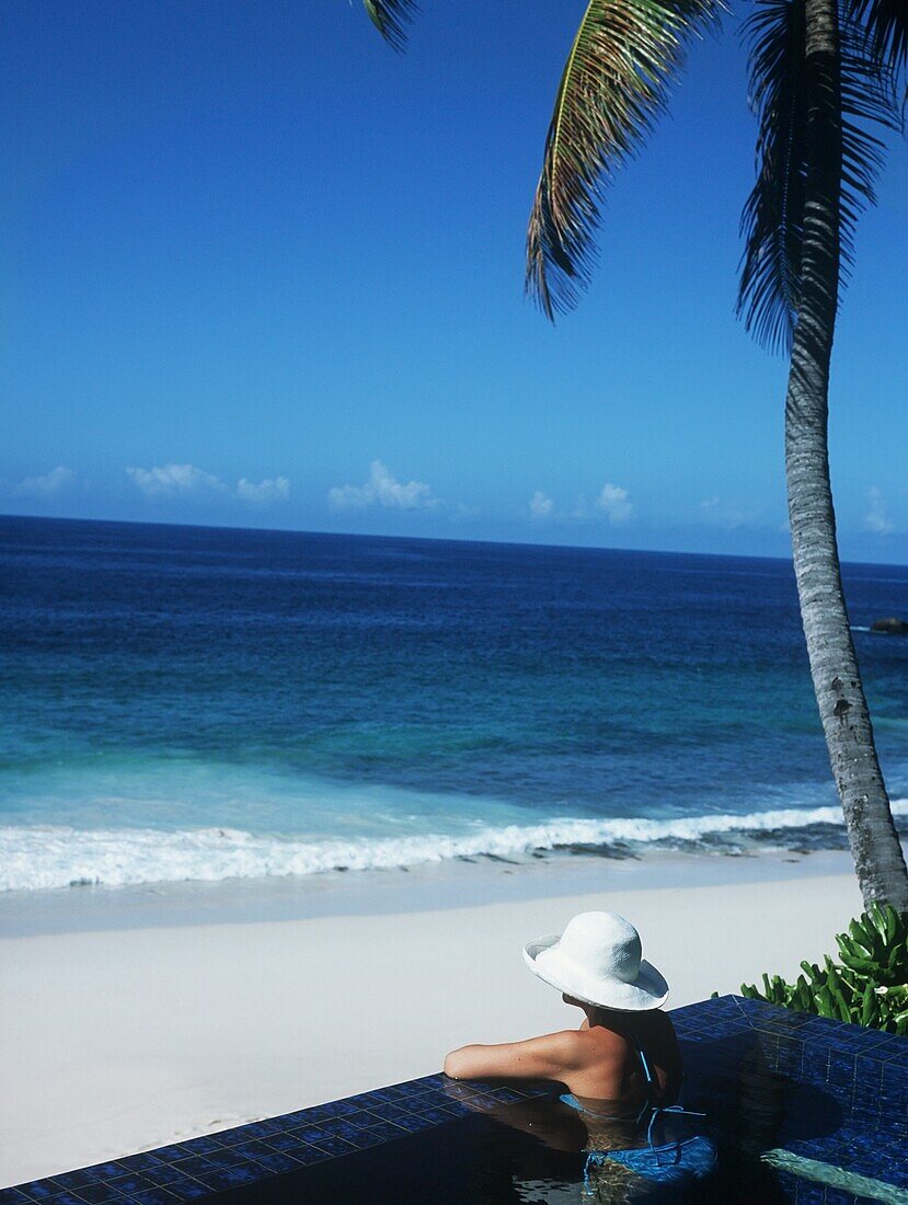 Tourist im Schwimmbad mit Blick auf das Meer