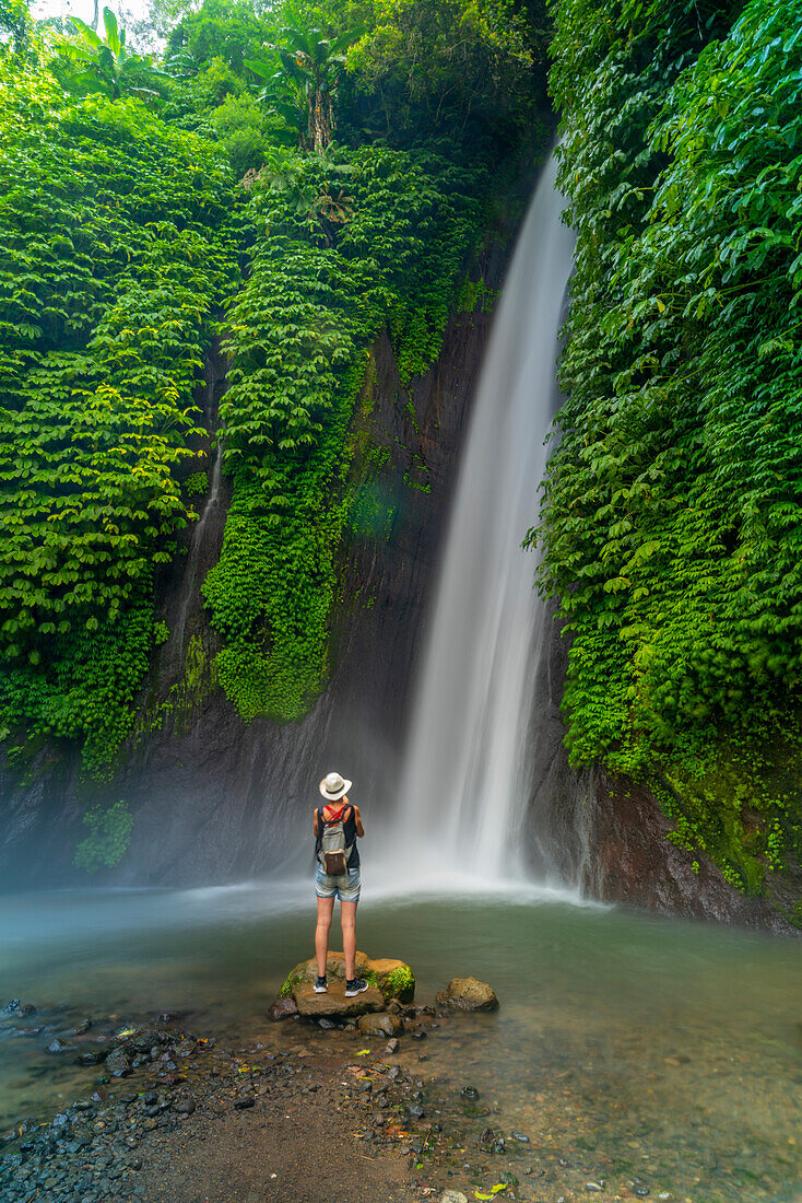 Blick auf eine Frau, die ein Foto am Melanting-Wasserfall macht, Kabupaten Buleleng, Gobleg, Bali, Indonesien, Südostasien, Asien
