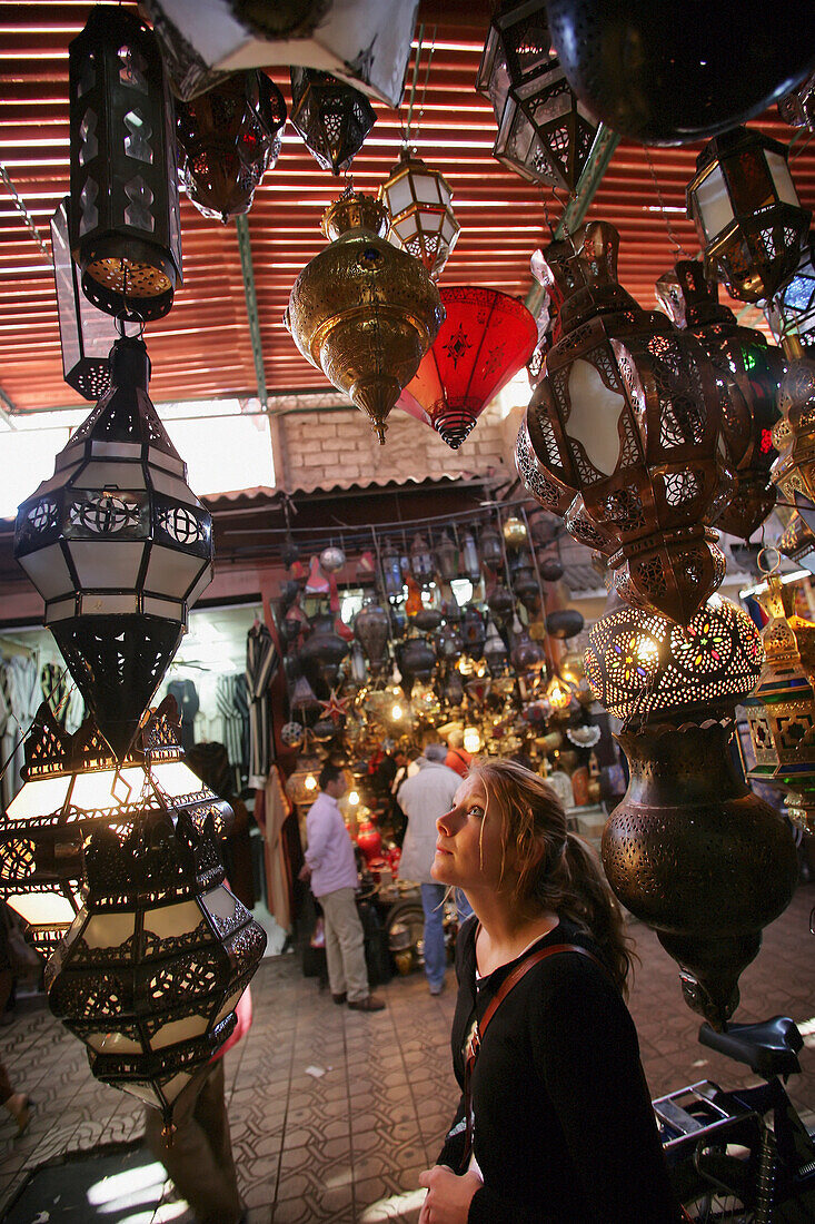 Young Woman Browsing For Moroccan Lanterns In A Market Stall In The Souk.