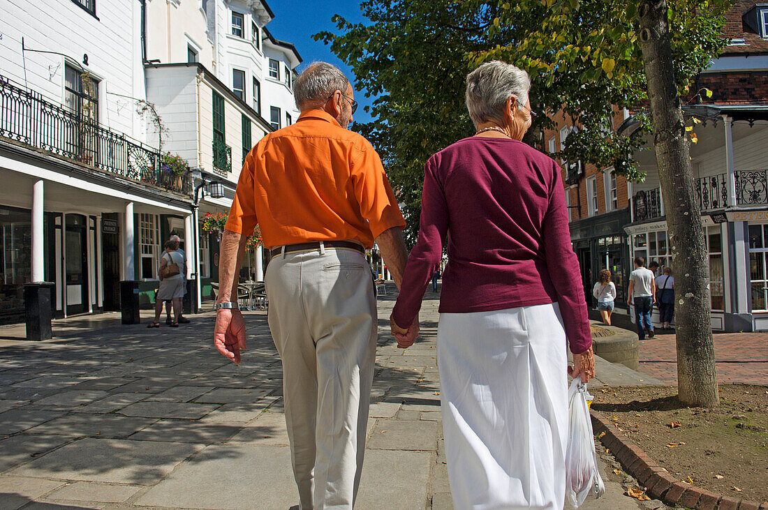 Rear View Of Elderly Couple Walking Down The Pantiles.