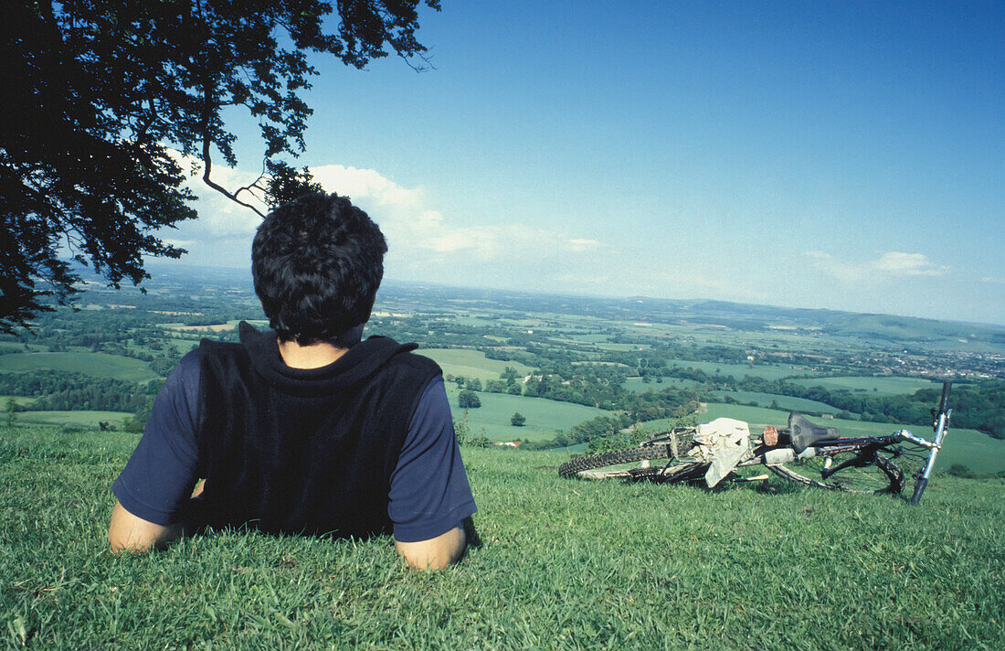 Mann ruht sich auf einem Hügel aus