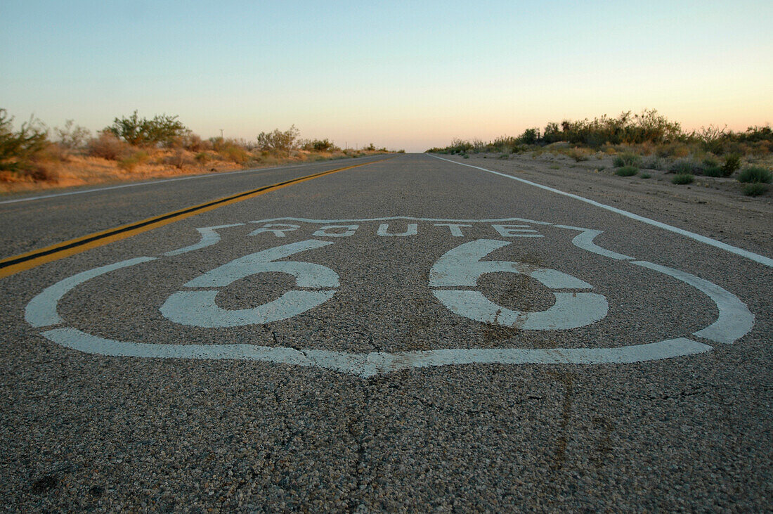 Route 66 Zeichen auf der Autobahn in der Wüste gemalt.