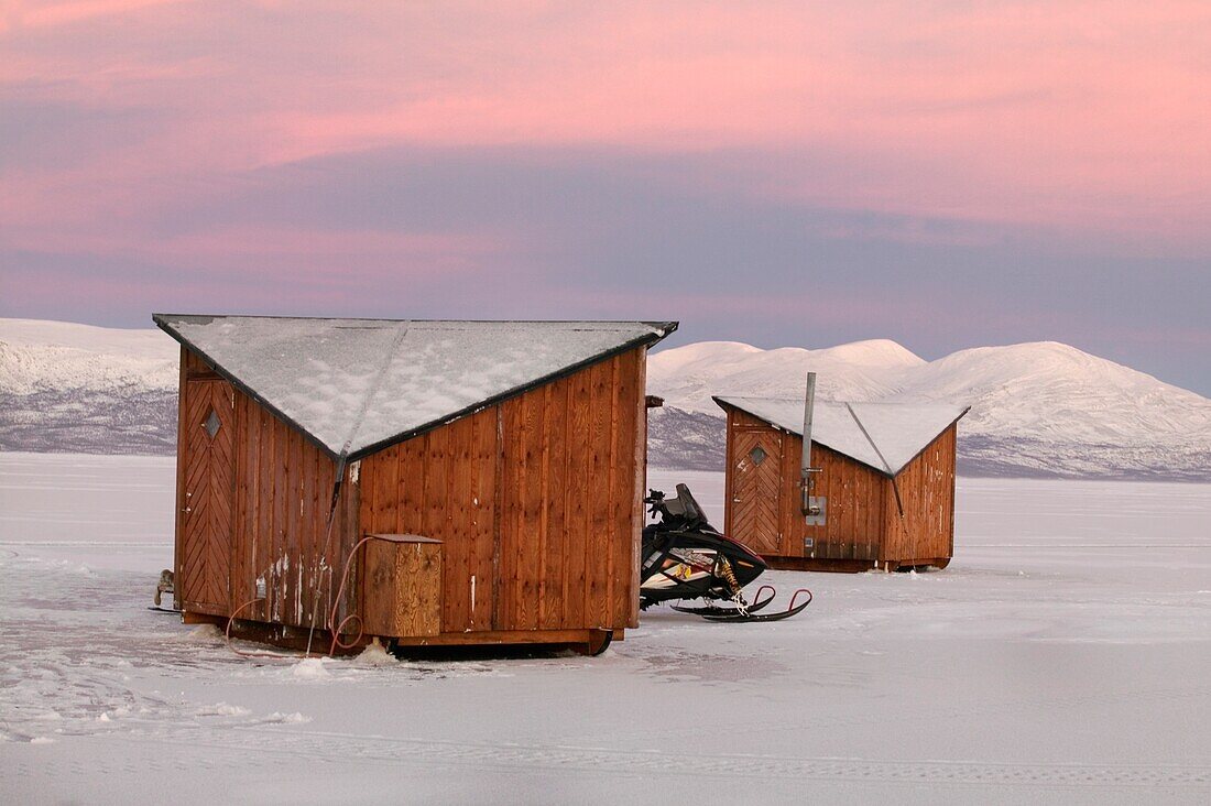 Schneemobil vor den kleinen Hütten des Abisko Ark Hotels