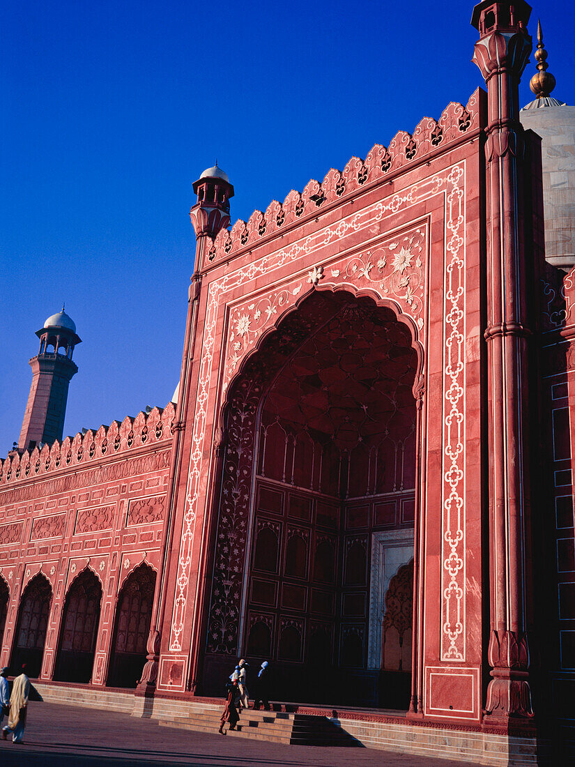 Menschen gehen in Richtung Badshahi Moschee