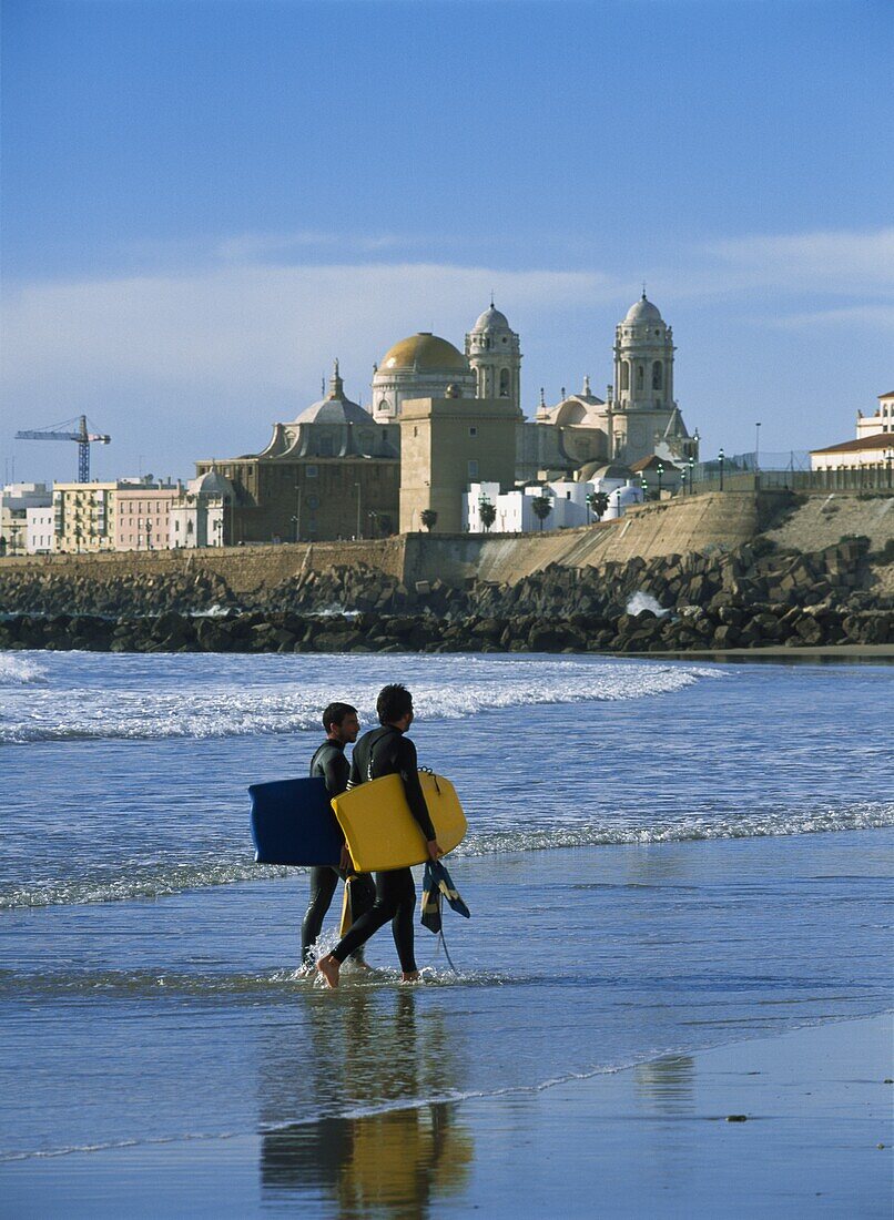 Surfers Walking Ashore In Front Of Santa Cruz Cathedral