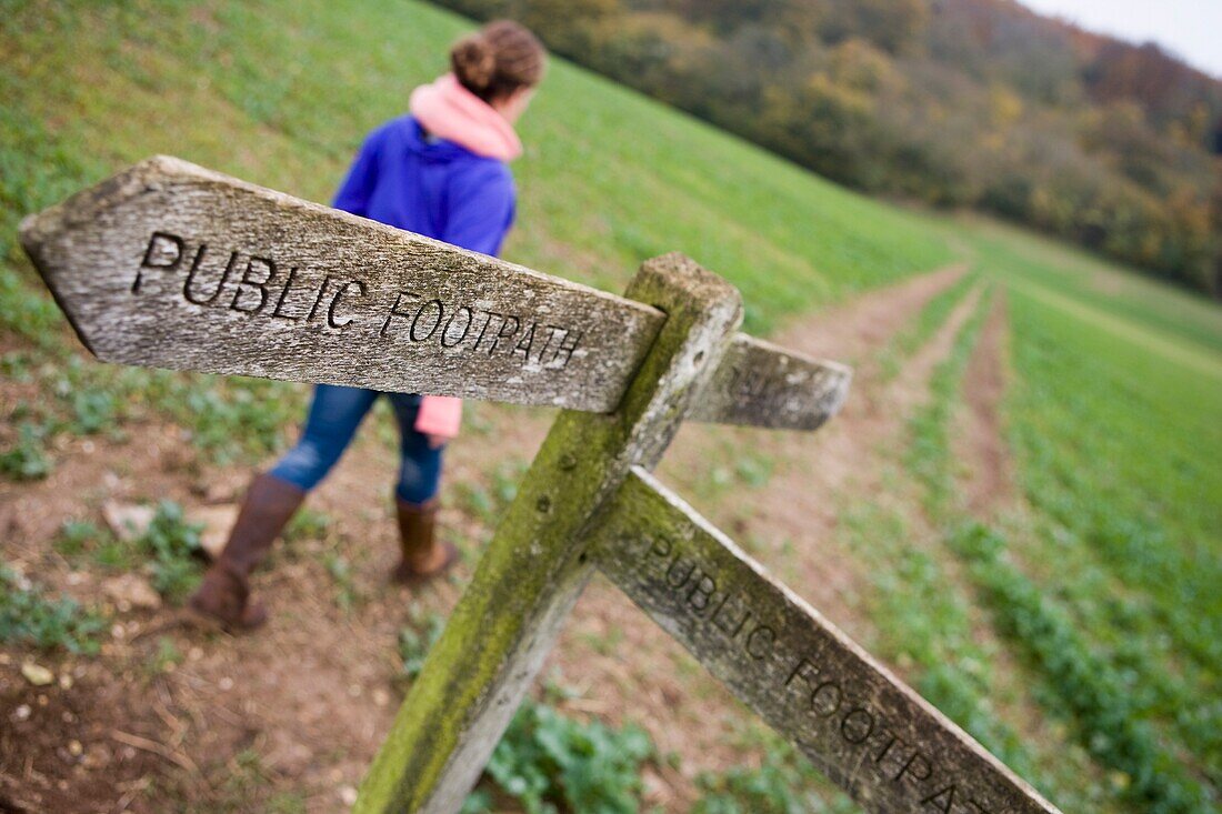 Junge Frau geht auf einem Feld, Herbst