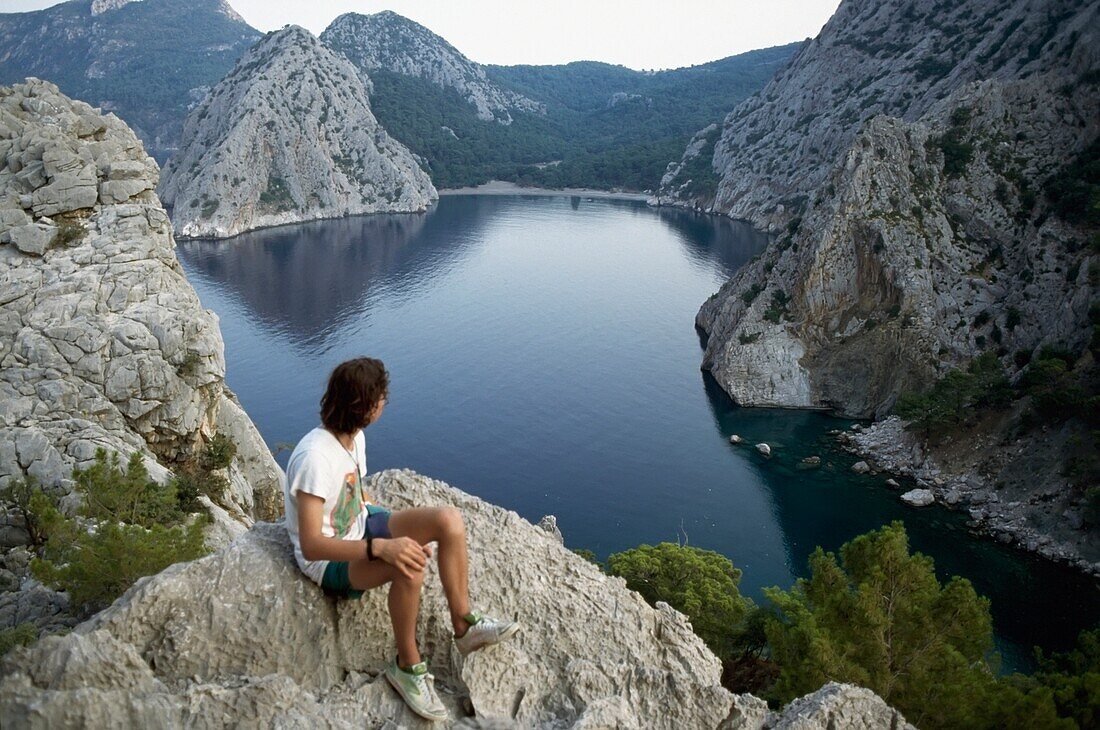 Man Sitting On Cliff, Looking At View