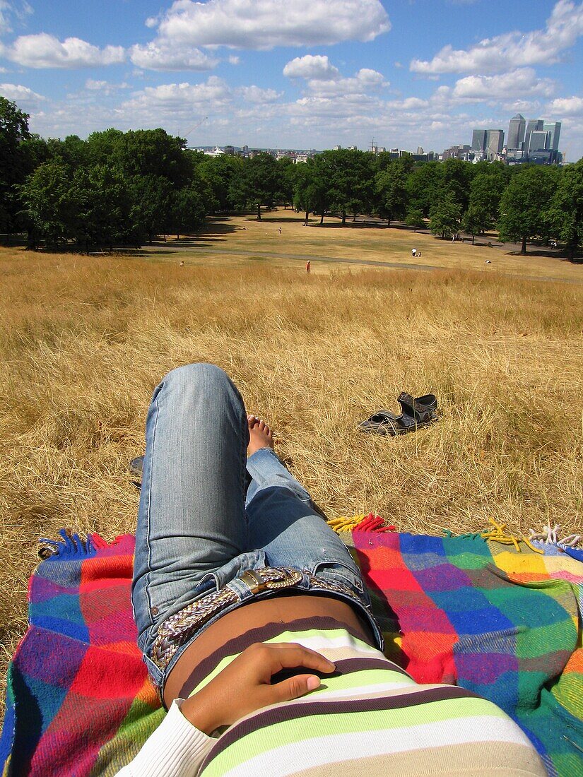Niedriger Ausschnitt einer Frau, die sich auf einer Decke im Park ausruht