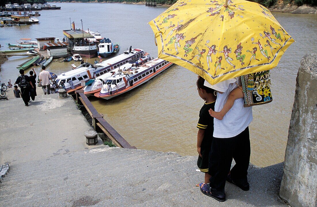 Family With Umbrella Near Rejang River At A Kapit