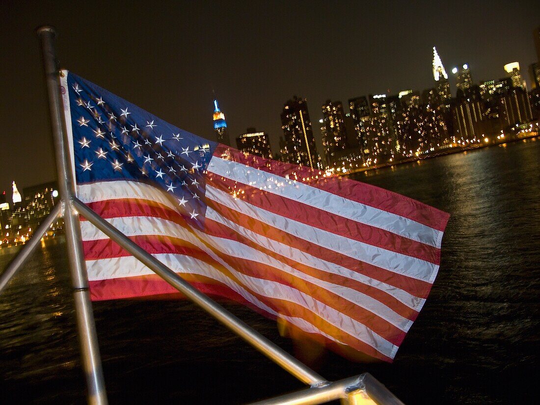 American Flag In Front Of Manhattan Skyline At Night
