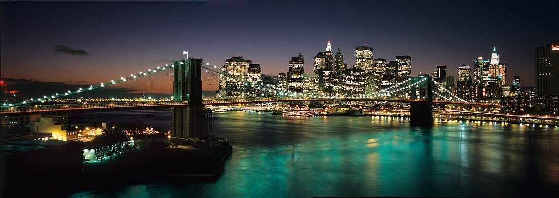 Brooklyn Bridge und Lower Manhattan in der Abenddämmerung von der Manhattan Bridge aus