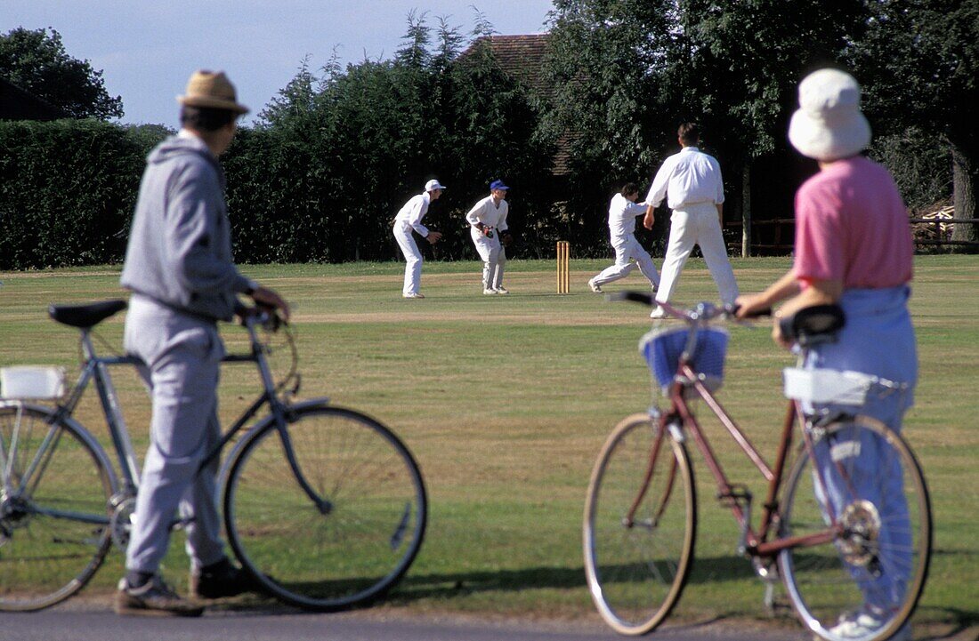 People With Bicycles Watching Cricket Game