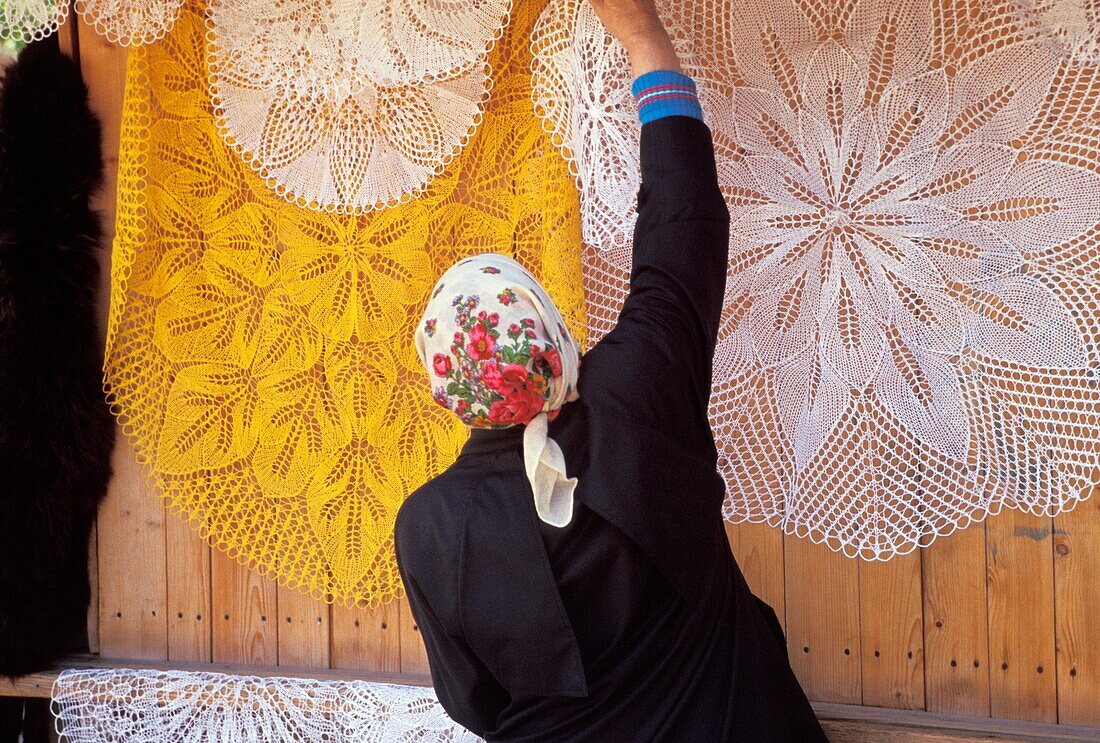 Woman Hanging Traditional Lace Tablecloths In Street Market