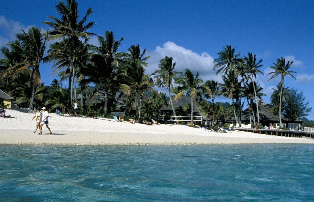 Tourists Walking On Beach