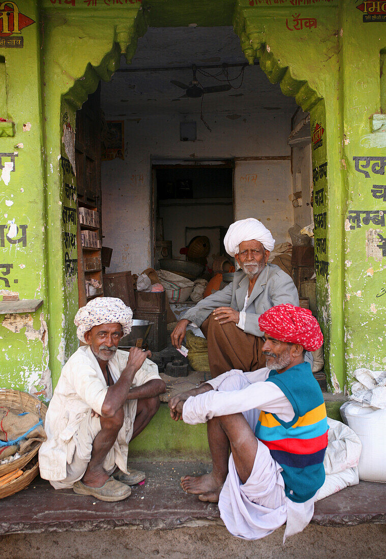 Men Sitting Outside House