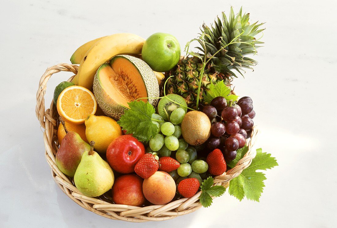 Various fruits and galia melon in wicker basket