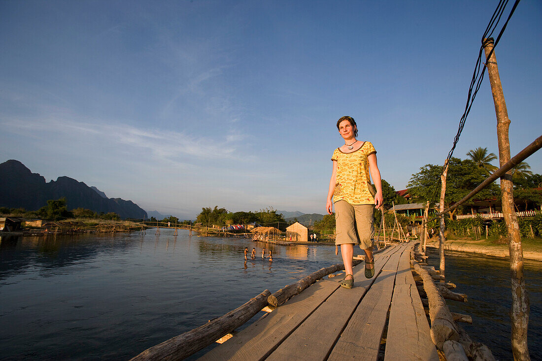 Junge Frau, die den Nam Song überquert, Vang Vieng, Laos
