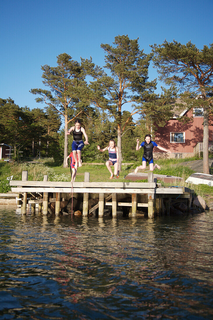 Children (8-15) Jumping Off Pier Into Sea, Foglo,Aland Islands,Finland