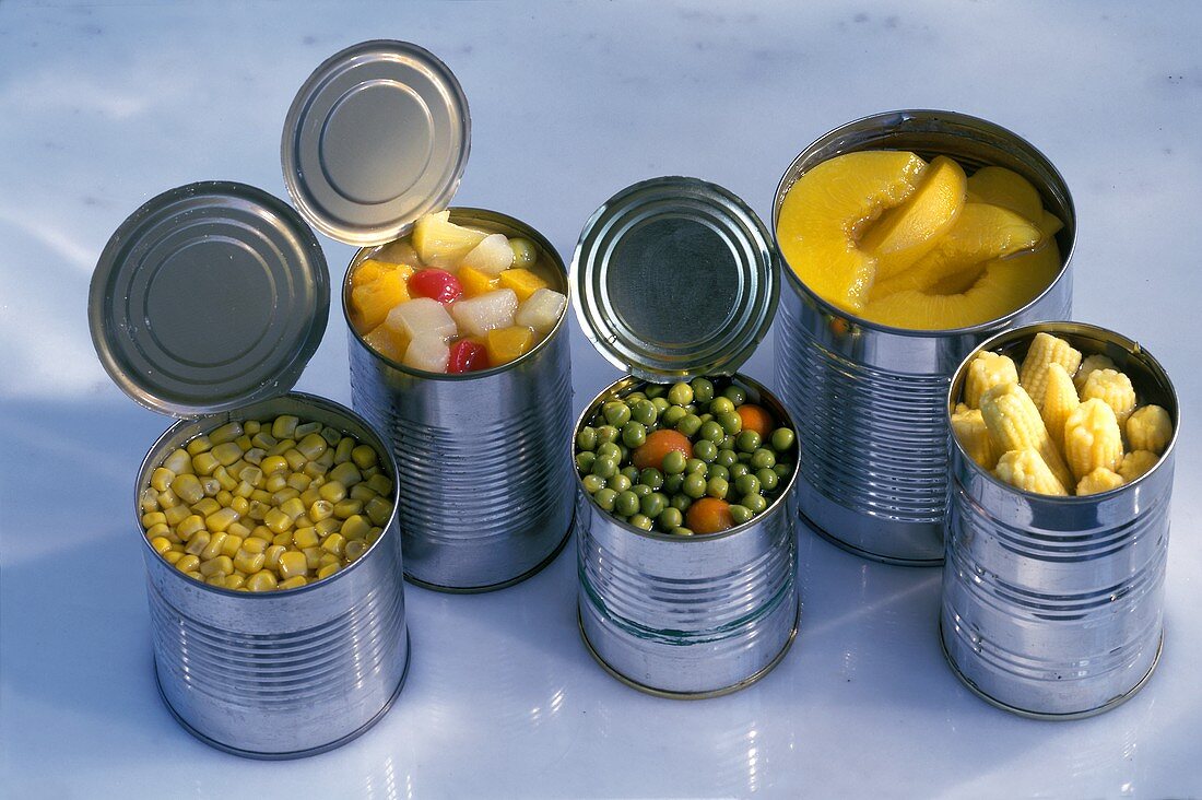 Mehrere geöffnete Konservendosen mit Gemüse & mit Früchten