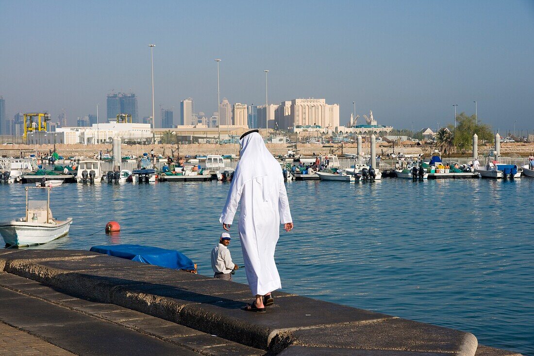 Mann in traditionellem Gewand und Skyline der Doha-Bucht, Doha, Katar