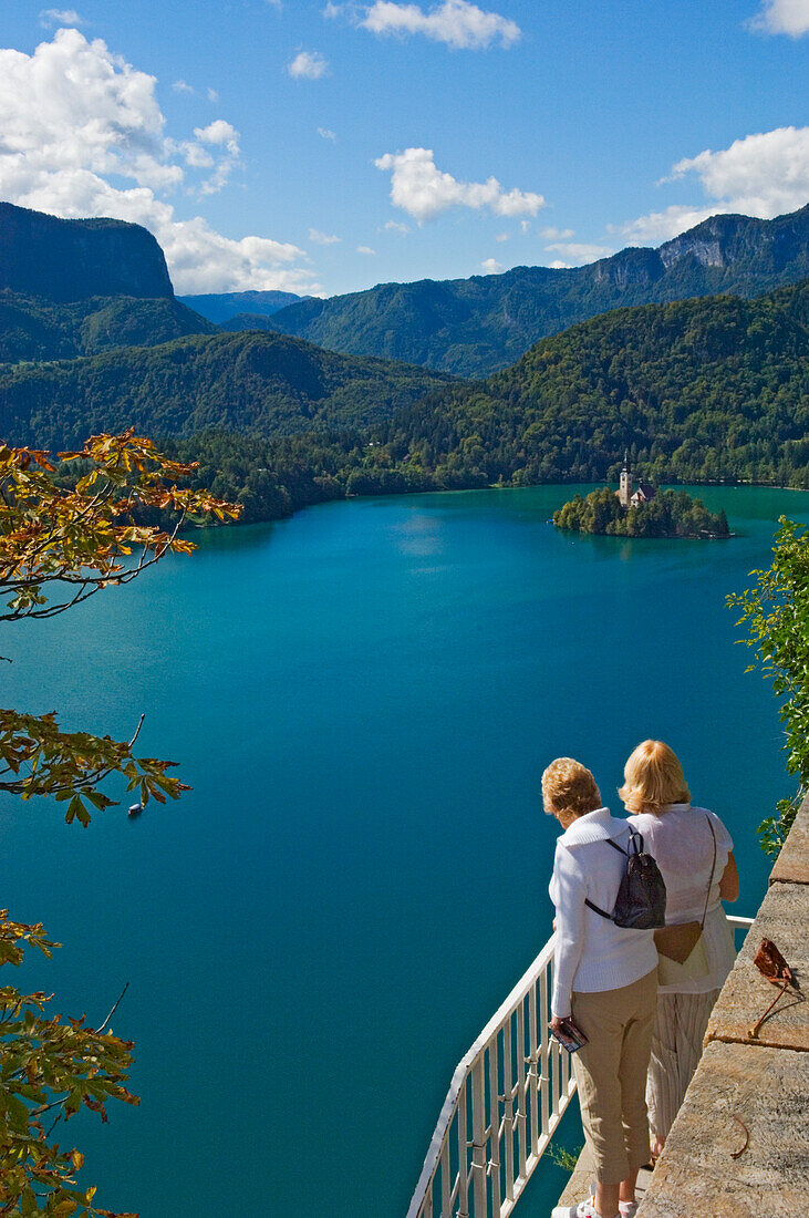Zwei Touristen schauen von der Schlossterrasse auf den Bleder See