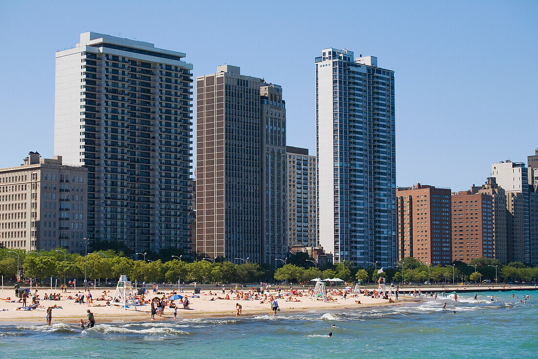 Menschen am Oak Street Beach mit Hochhäusern im Hintergrund, Chicago, Illinois, USA