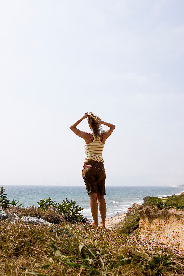 Woman On Cliff Facing Ocean,Rear View, Ditch Plains,Montauk,Long Island,New York,Usa