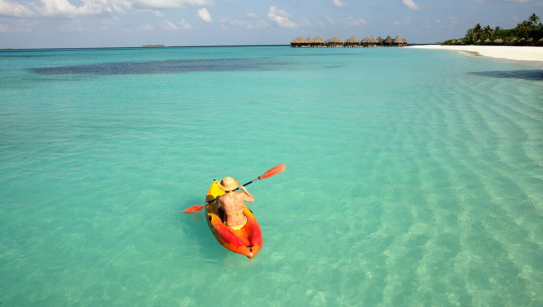 Frau paddelt Kanu auf dem Meer, erhöhte Ansicht, Dhuni Kolhu Island, Malediven