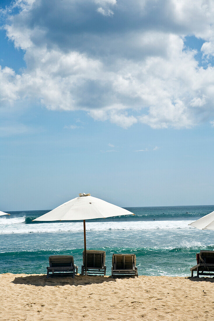 Sonnenschirm und Stühle am Strand
