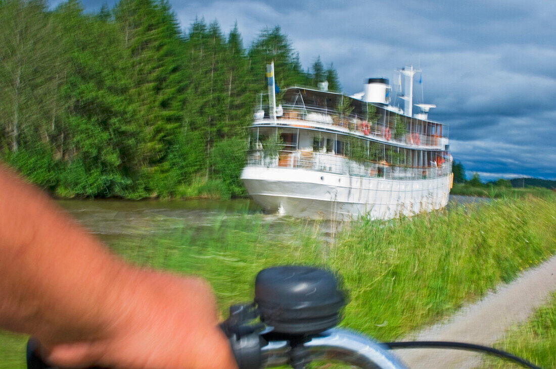 Person fährt mit dem Fahrrad entlang des Gota-Kanals, Schweden