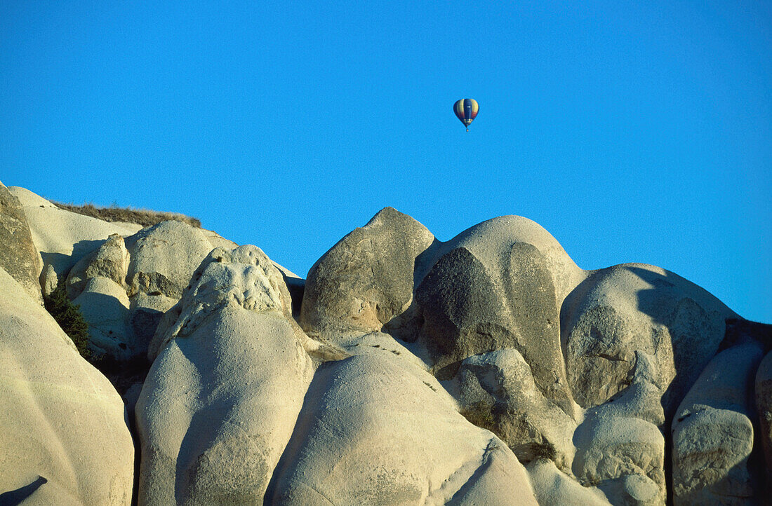 Heißluftballon über Landschaft in Kappadokien, Türkei