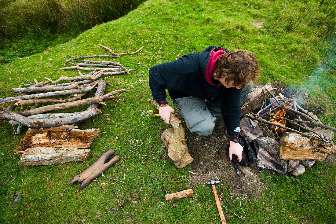 Mann bereitet Lagerfeuer auf einem Feld vor, Dartmoor National Park,Postbridge,Yelverton,Devon,Uk