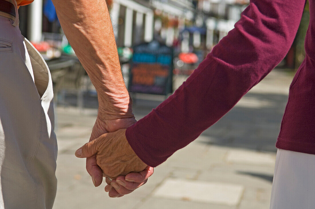 Älteres Paar, das sich an den Händen hält, Mittelteil, Pantiles, Tunbridge Wells, Kent, Großbritannien