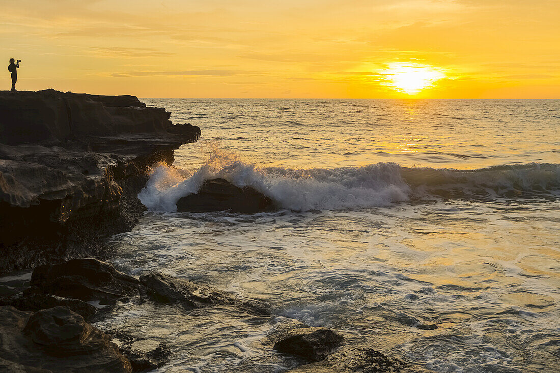 Goldener Sonnenuntergang über dem Ozean mit Blick auf die Küste; Insel Bali, Indonesien