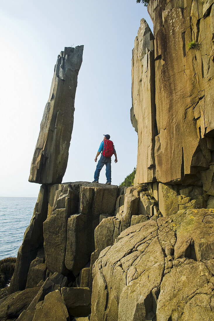 Wanderer mit Blick auf den Balancing Rock und die Basalt Rock Cliffs, Bay Of Fundy; Long Island, Nova Scotia, Kanada.